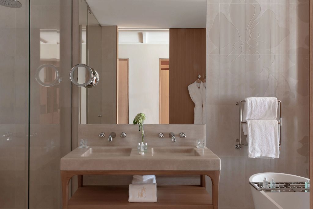 Stilvolle Waschtische mit zwei Waschbecken und dekorativem Spiegel im Badezimmer.
