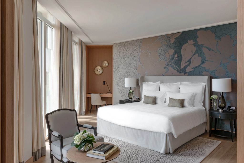 Luxuriöses Schlafzimmer mit großem Bett und eleganter Tapete mit floralen Motiven