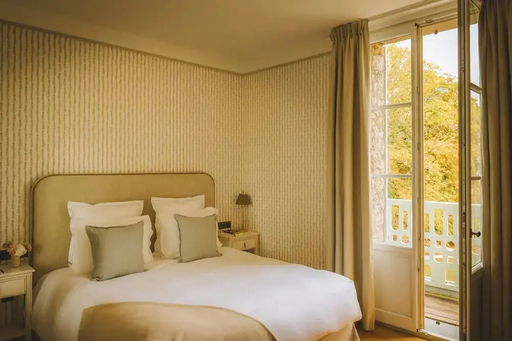 Einladendes Schlafzimmer mit Doppelbett, weichen Kissen und Aussicht auf Natur.