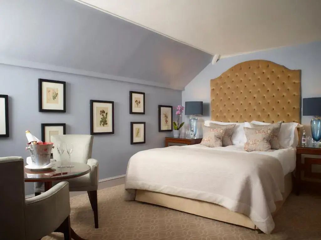 Geräumiges Deluxe-Doppelzimmer mit gemütlichem Sessel und Wandkunst