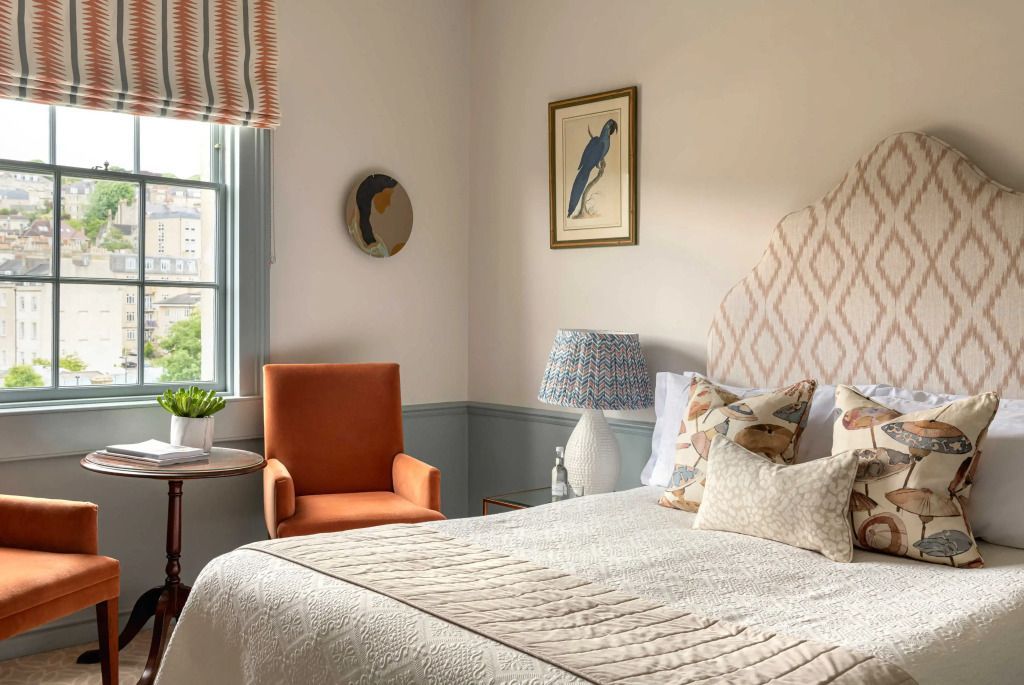 Elegantes klassisches Zimmer mit orangefarbenem Sessel und stilvollen Kunstwerken.