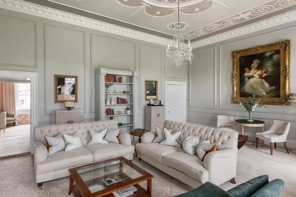 Edles Wohnzimmer mit zwei Sofas und antikem Bücherregal