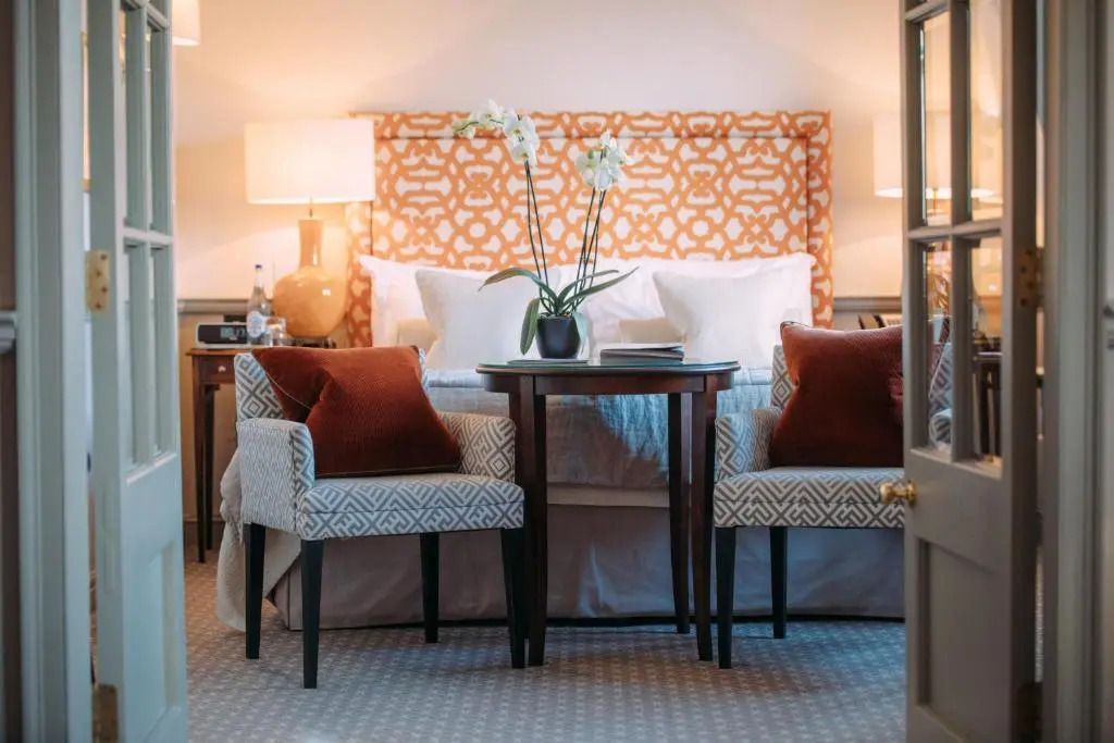 Gemütliches Schlafzimmer mit stilvollen Sesseln und elegantem Bett