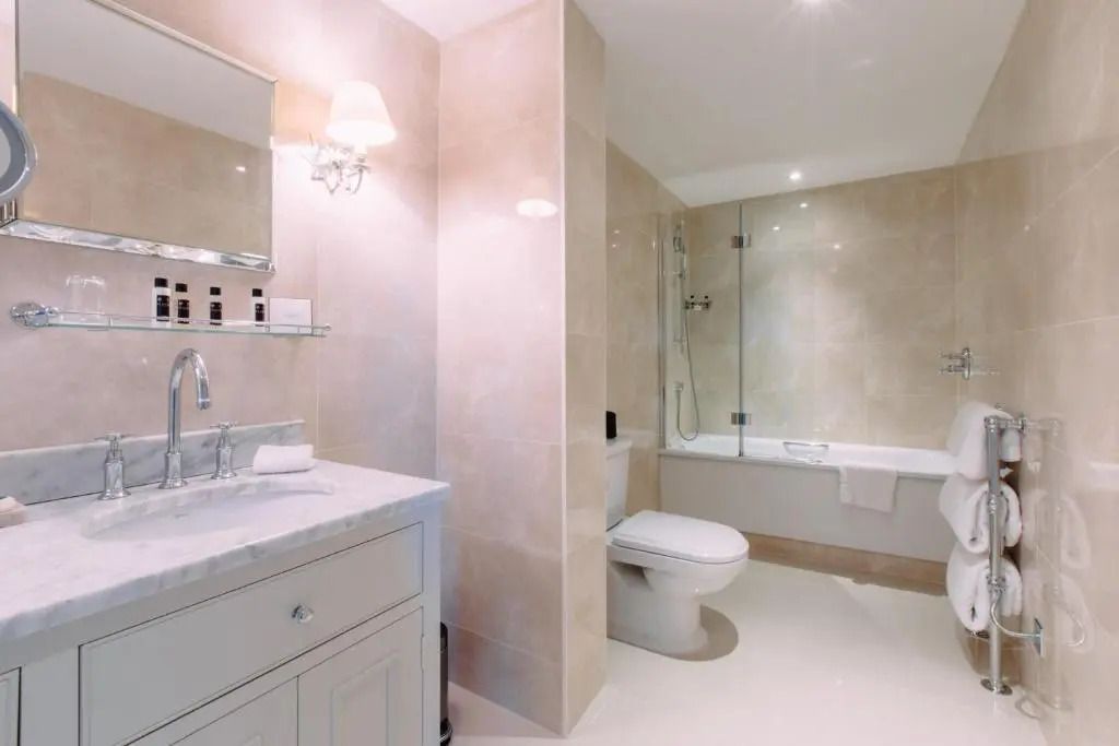 Helles Badezimmer mit Badewanne, Dusche und elegantem Waschtisch