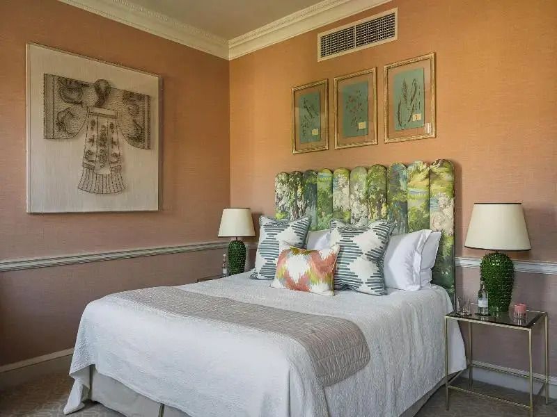 Charmantes Zimmer mit Doppelbett, Kunstwerken an der Wand und eleganter Beleuchtung
