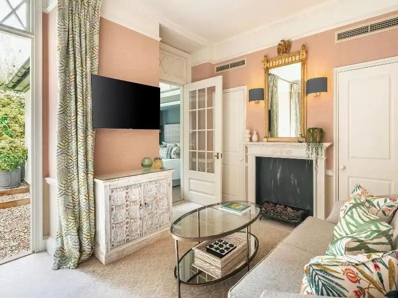 Luxuriöses Wohnzimmer mit Kamin, TV und eleganten Möbeln