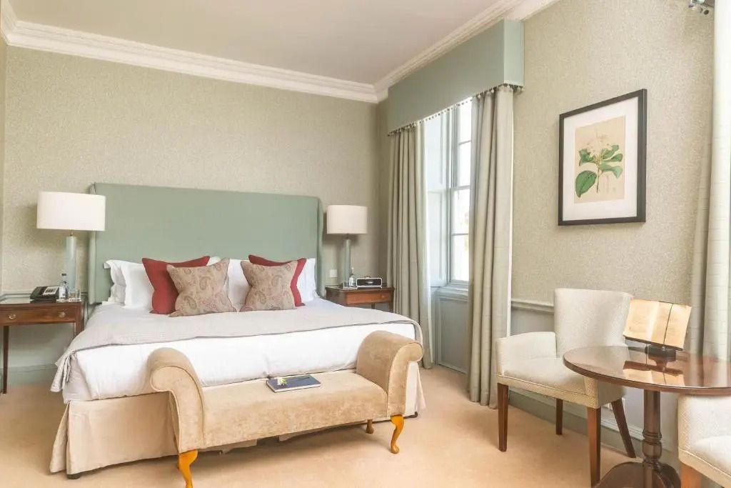 Elegant eingerichtetes Zimmer mit Pastellfarben und gemütlichem Sessel.