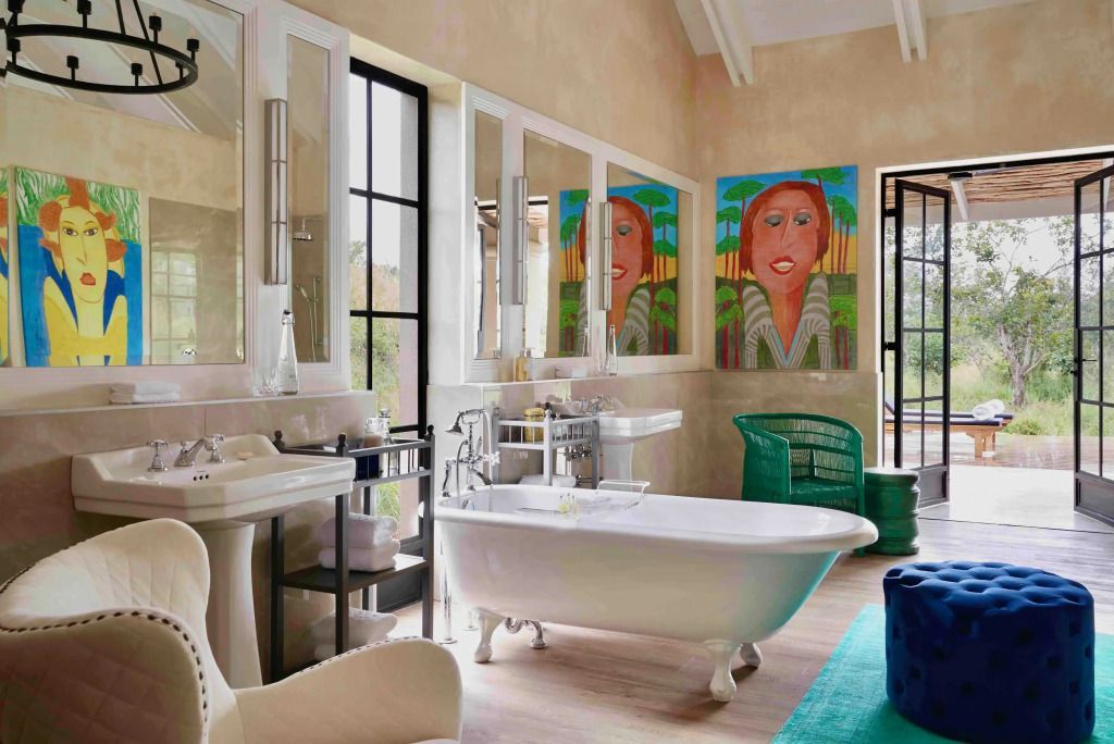 Badezimmer mit künstlerischer Dekoration und freistehender Badewanne