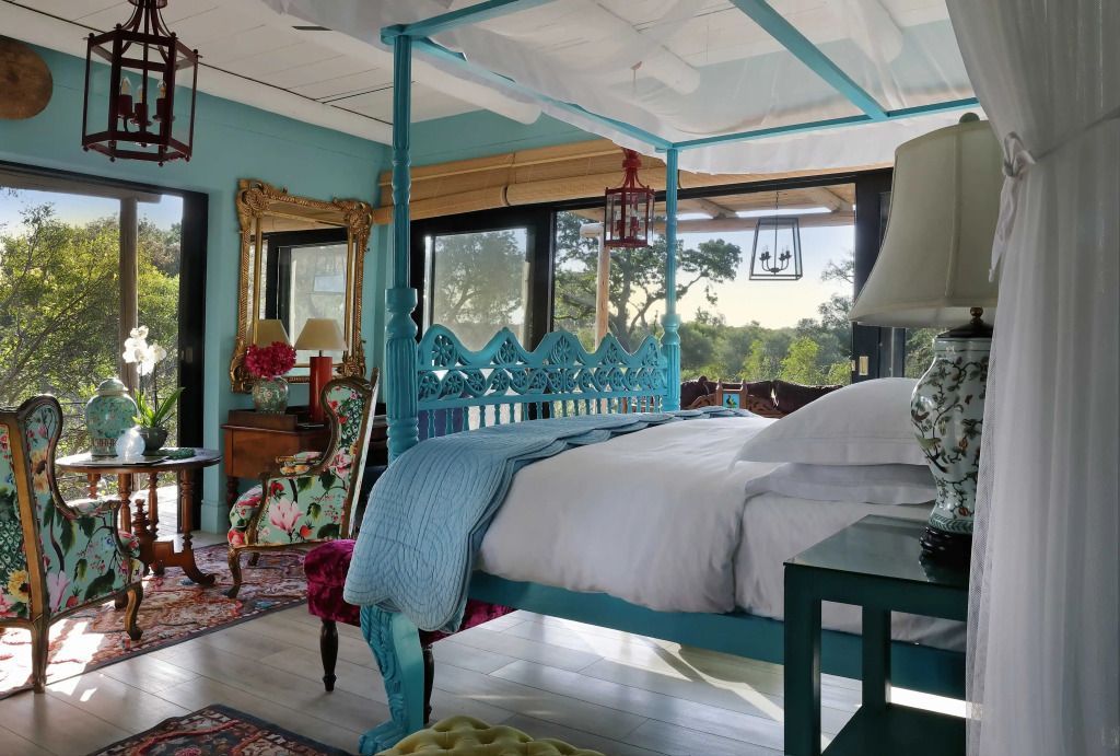 Luxuriöses Schlafzimmer mit Himmelbett und Aussicht auf Natur