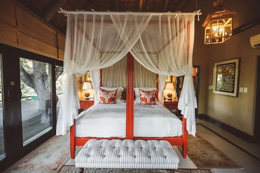 Elegantes Schlafzimmer mit Himmelbett und großen Fenstern in der Royal Suite