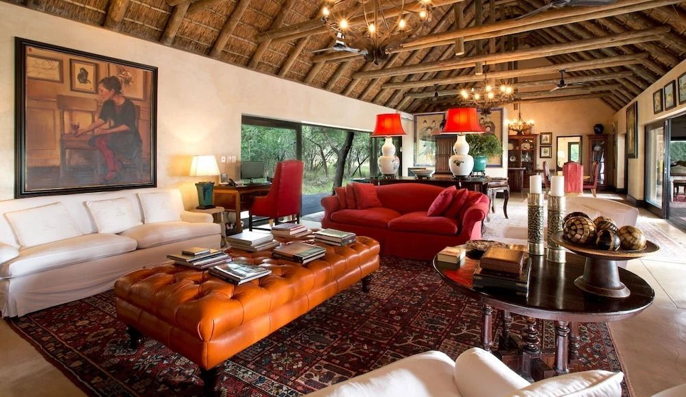 Elegante Lounge mit roten Sofas und stilvollem Dekor im afrikanischen Stil