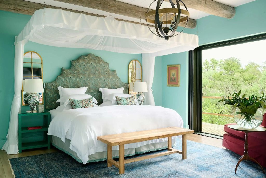 Helles Schlafzimmer in der Suite mit großer Fensterfront und geschmackvollen Details