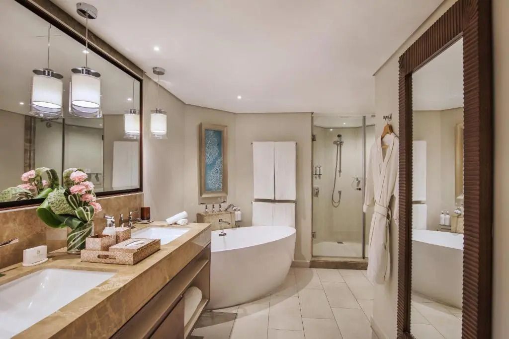 Modernes Badezimmer der Doppel Suite im Royal Palm Beachcomber mit freistehender Badewanne und großer Dusche.