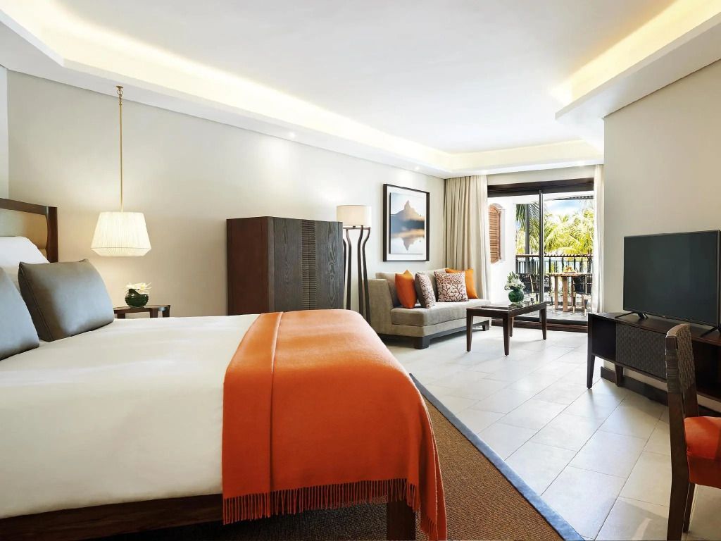 Helle Junior-Suite mit stilvollem Interieur und Balkon mit Gartenblick.
