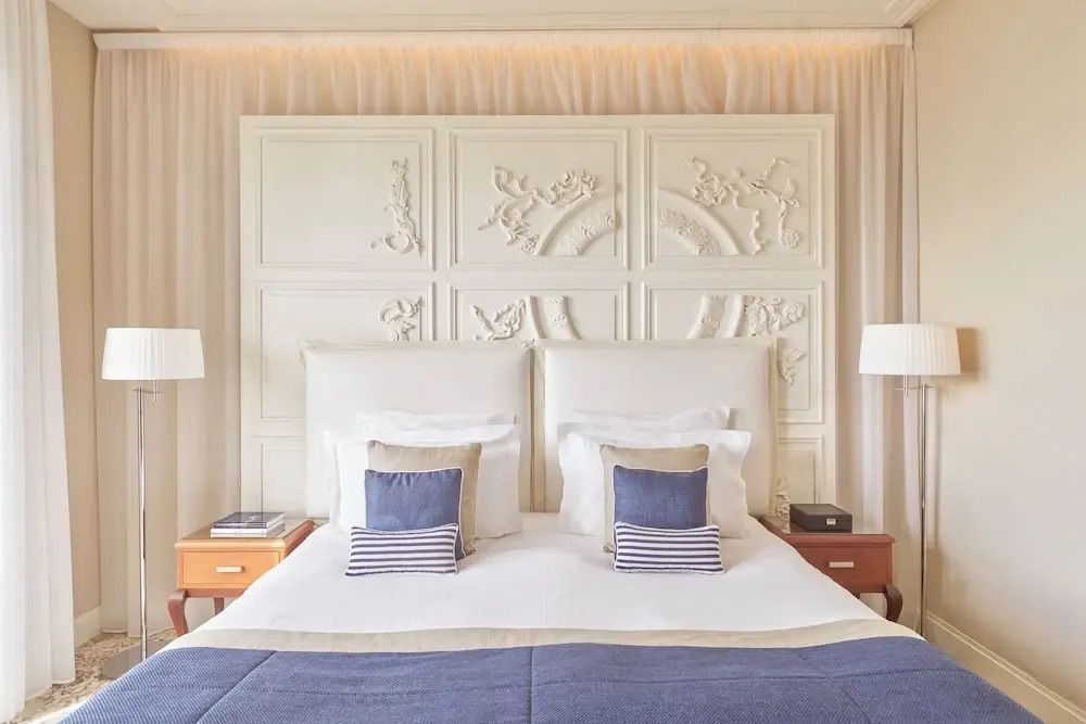 Elegantes Doppelbett mit dekorativer Wandverzierung und blauen Akzenten im Hotelzimmer