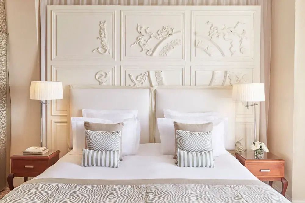 Komfortables Bett mit künstlerischer Verzierungswand und stilvollen Kissen im Zimmer