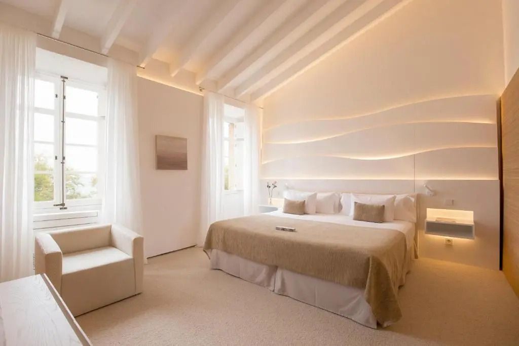 Lichtdurchflutetes Hotelzimmer mit elegantem Doppelbett und heller Einrichtung