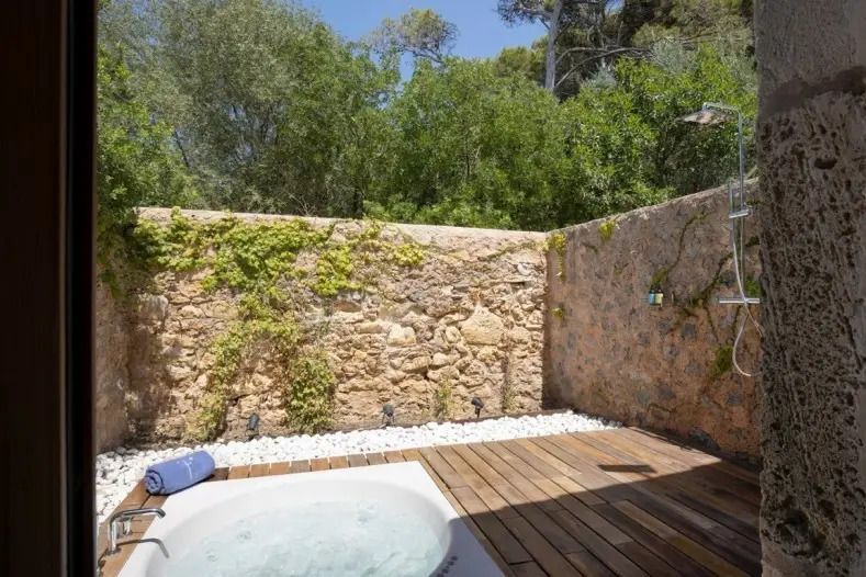 Private Terrasse mit Whirlpool und Natursteinmauer im Garten