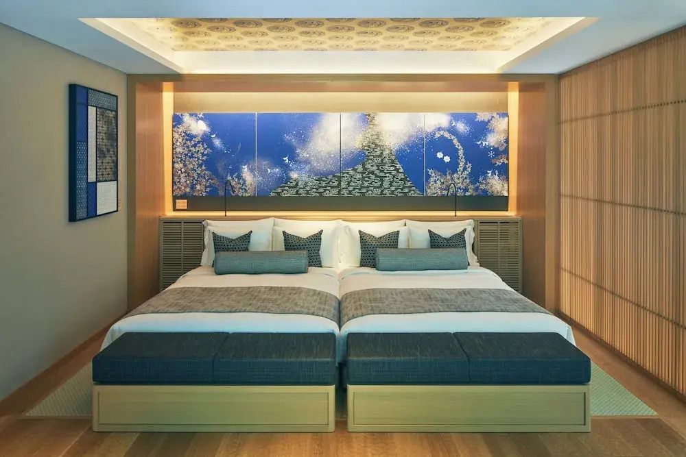 Helles Schlafzimmer mit zwei Einzelbetten und stilvoller Wandkunst