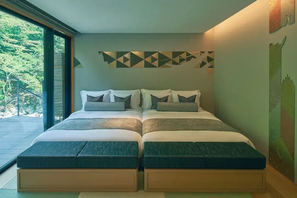 Doppelbett in einem modernen Schlafzimmer mit geometrischem Wanddesign