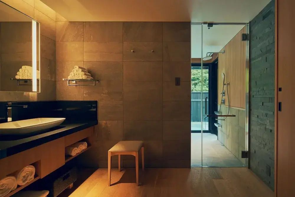 Luxuriöses Badezimmer mit Glasdusche, hölzernen Akzenten und Waschbecken
