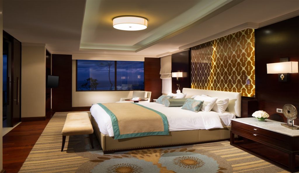 Luxuriöses Schlafzimmer mit großem Bett und Meerblick durch Panoramafenster