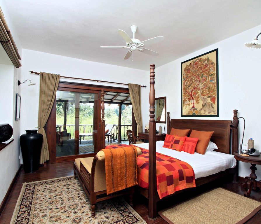 Geräumiges Schlafzimmer mit Himmelbett und Zugang zur Terrasse mit Naturblick
