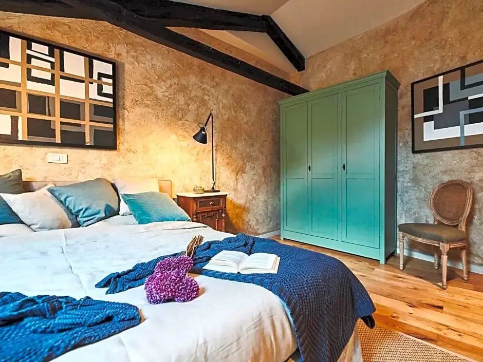 Modernes Schlafzimmer mit Holzbalken und türkisfarbenem Schrank neben bequemen Bett