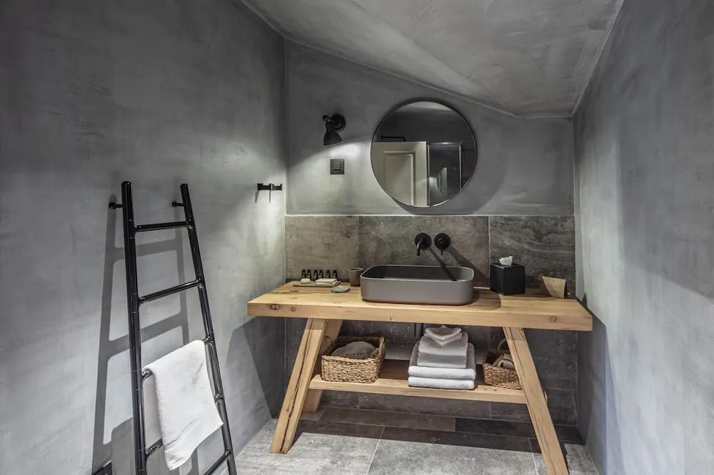 Modernes Badezimmer mit Rundspiegel und Holzwaschtisch