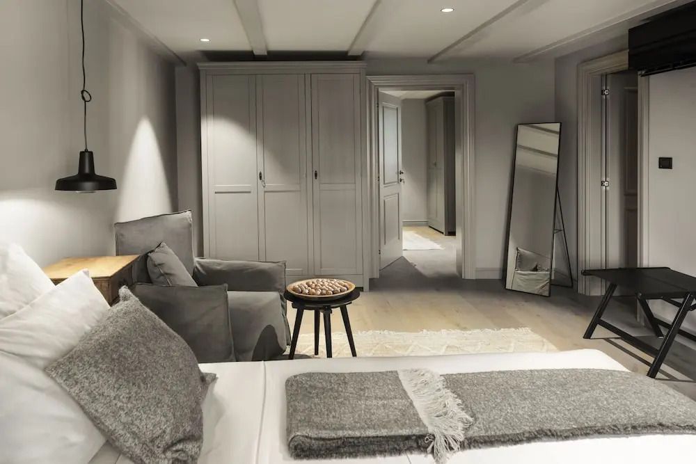 Gemütliches Schlafzimmer mit grauem Sessel und großem Kleiderschrank