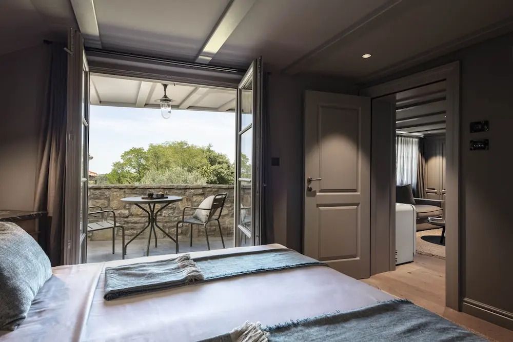 Schlafzimmer mit Blick auf Terrasse und grüne Landschaft