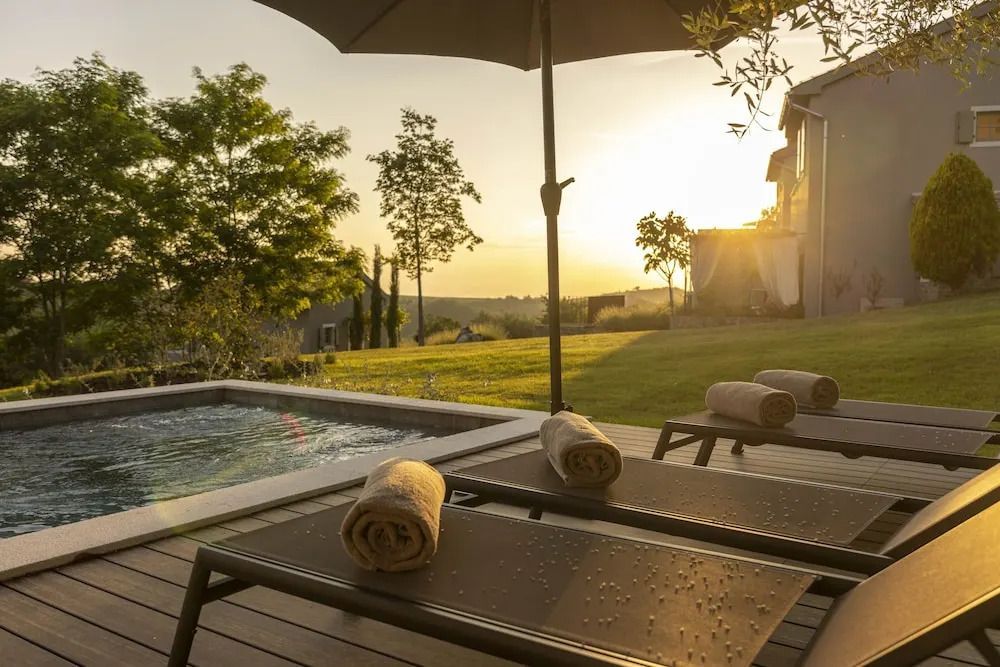 Sonnenliegen und kleiner Pool im Garten bei Sonnenuntergang