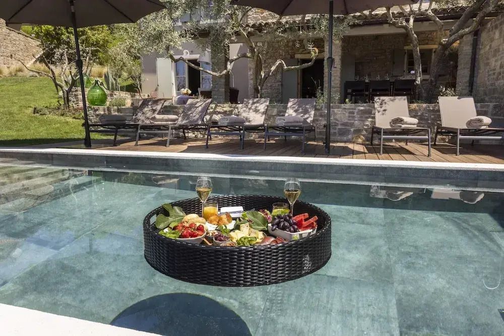 Schwimmendes Frühstückstablett im Pool vor der Villa