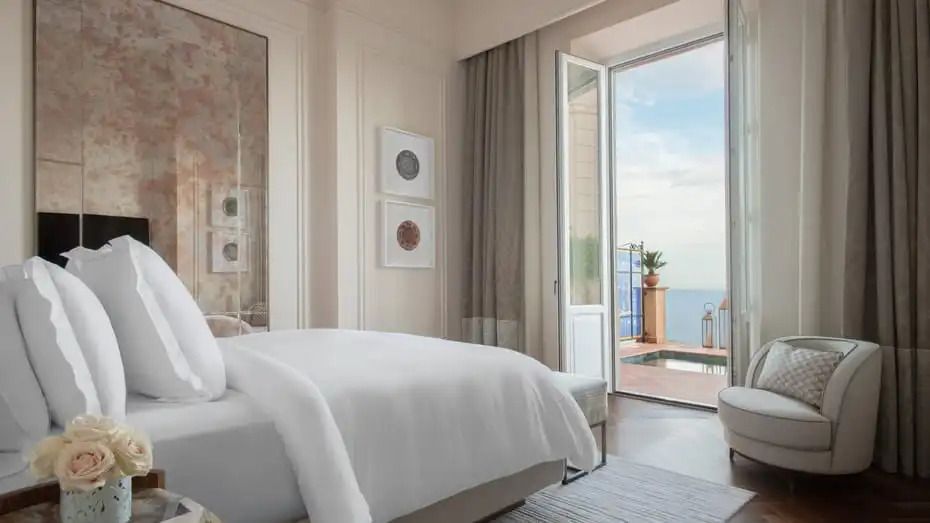 Elegantes Schlafzimmer mit Doppelbett und Terrasse mit Meerblick