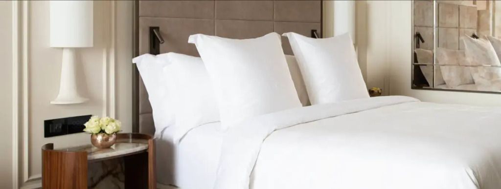 Elegantes Doppelbett mit weichen, weißen Kissen und moderner Kopfleiste