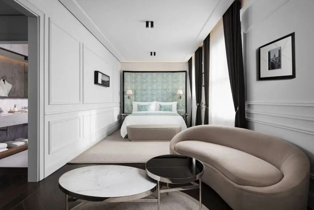 Elegantes Hotelzimmer mit Doppelbett, stilvollem Sofa und Couchtisch