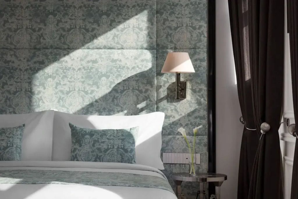 Detailansicht des Bettes mit dekorativen Kissen und Wandlampe