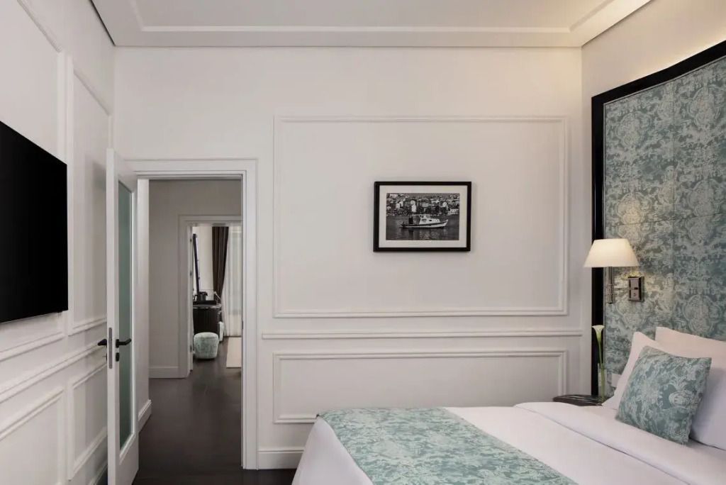 Elegantes Schlafzimmer mit Doppelbett und stilvoller Wanddekoration in einer Suite