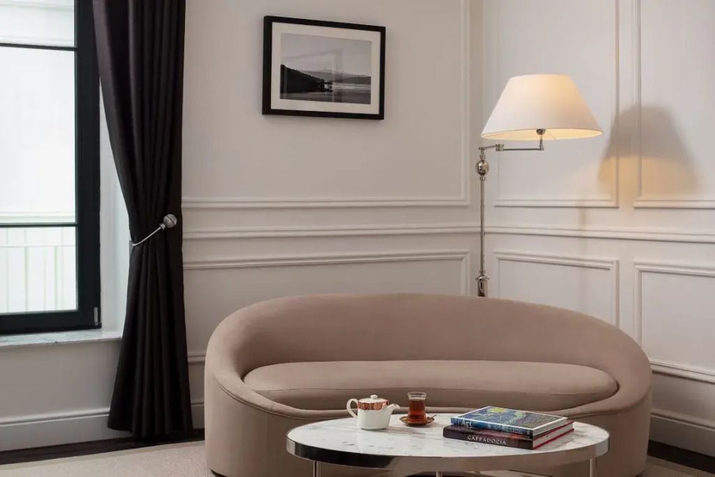 Gemütliche Sitzecke mit Sessel, Tisch und Bücher in einer stilvollen Suite