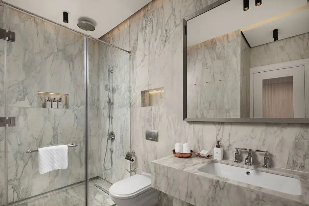 Luxuriöses Badezimmer mit Marmordekor und modernen Armaturen in der Suite