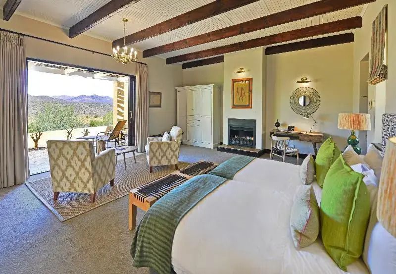 Großes Schlafzimmer in einer Suite mit Kamin und Blick auf die Landschaft
