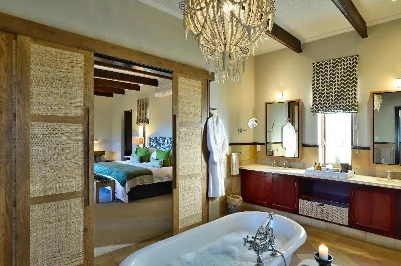 Luxuriöses Badezimmer mit freistehender Badewanne und Kronleuchter
