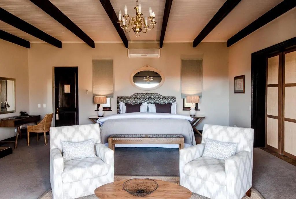 Elegantes Schlafzimmer mit Doppelbett und stilvollen Sesseln