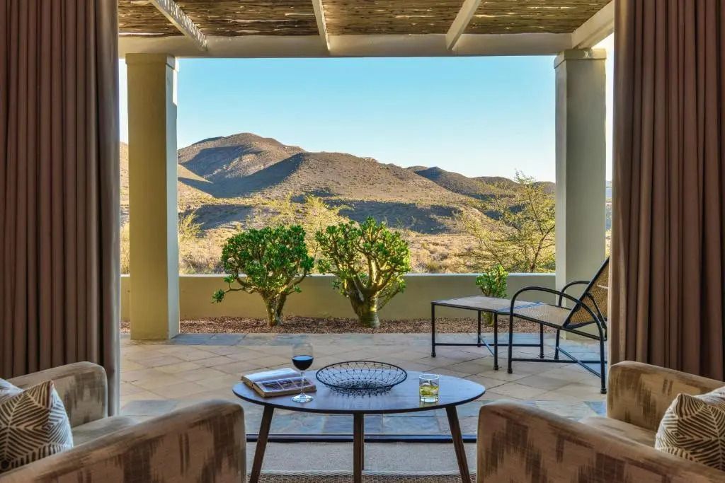 Terrasse mit Blick auf Berge und zwei Stühle mit Tisch
