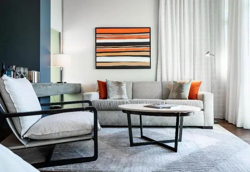 Modern eingerichtetes Wohnzimmer mit stilvollem Sofa und Kunstwerk an der Wand.