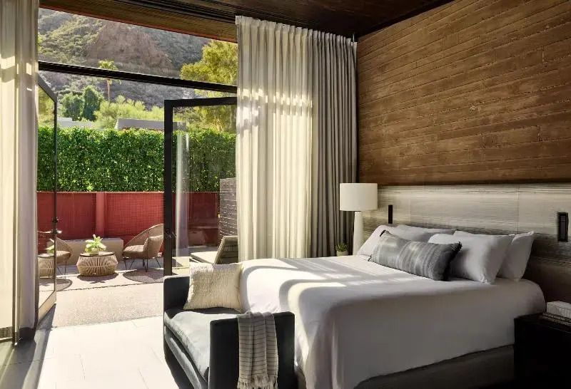 Gemütliches Schlafzimmer mit großem Bett und Aussicht auf Terrasse und Garten.