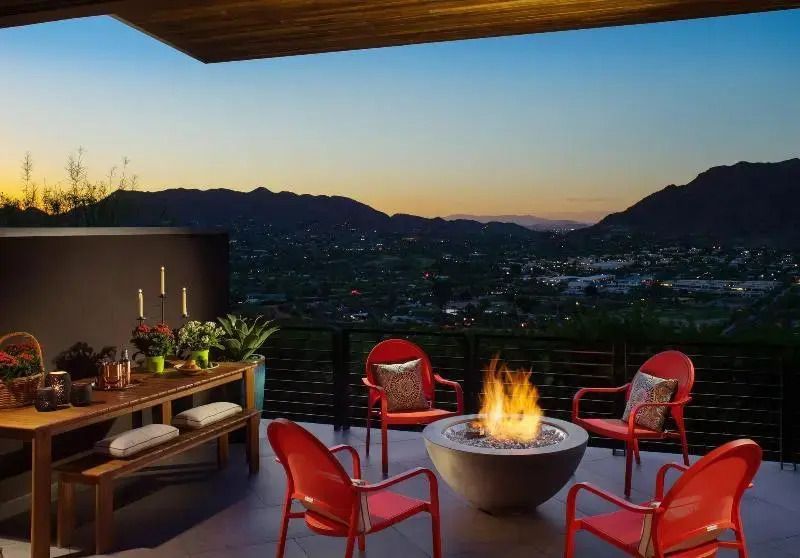 Terrasse mit Feuerstelle und weitem Blick über die Berglandschaft bei Sonnenuntergang