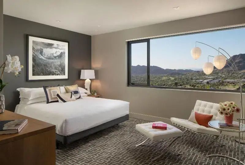 Schlafzimmer mit großem Bett und weitem Fensterblick auf die umliegende Landschaft