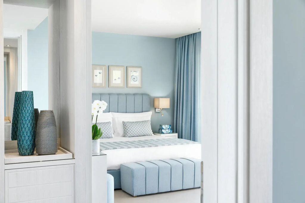 Geräumige Suite mit Doppelbett in hellblauen Farbtönen und elegantem Dekor