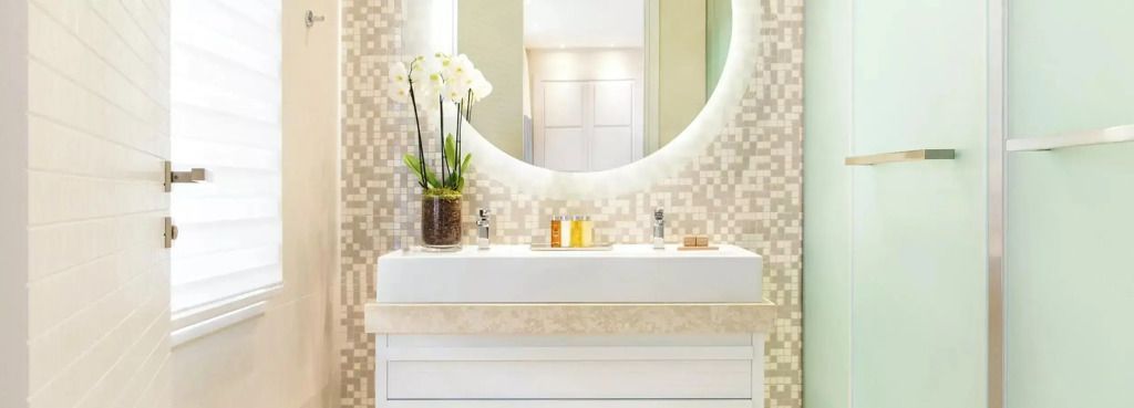 Modernes Badezimmer mit großer runder Spiegel und Blumenarrangement